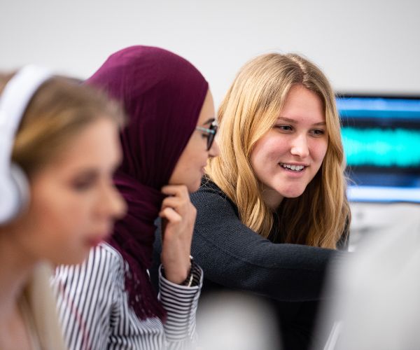 Journalism students working on a computer.