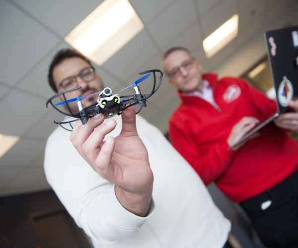 Computer Science professor and student working with a drone.