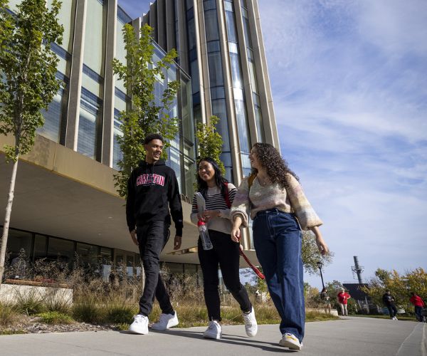 Three students walk outside of the Nicol Building.