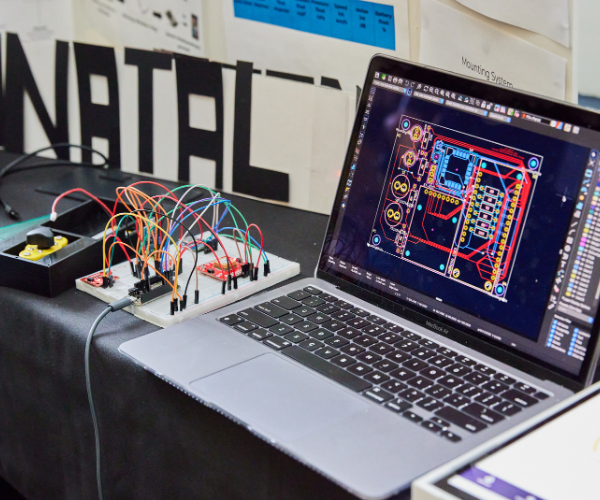 Students working on a bread board connected to a laptop