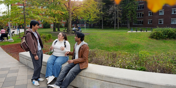 Three international students sitting in the residence quad