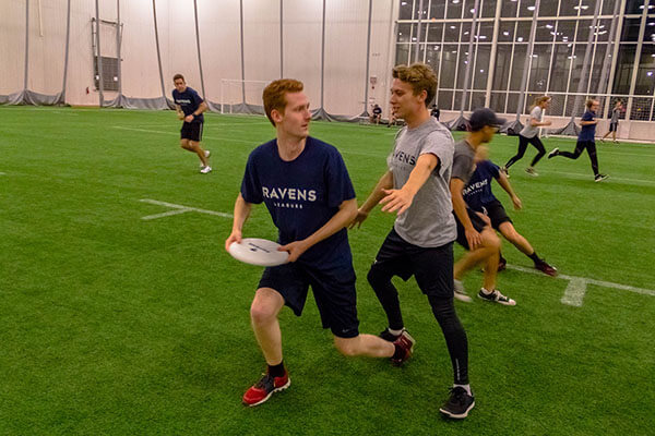 Students play Ultimate Frisbee in the Fieldhouse.
