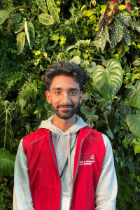 Student standing in front of the living wall