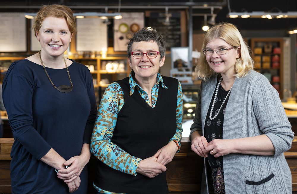 Kate Burnett, Tracey Clark and Dana Brown stand together in a Bridgehead coffees shop location.