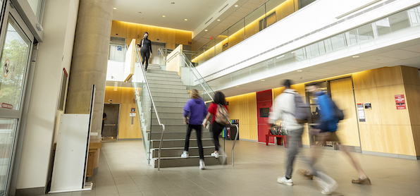 students walking up stairs in campus building, in blurred fast motion