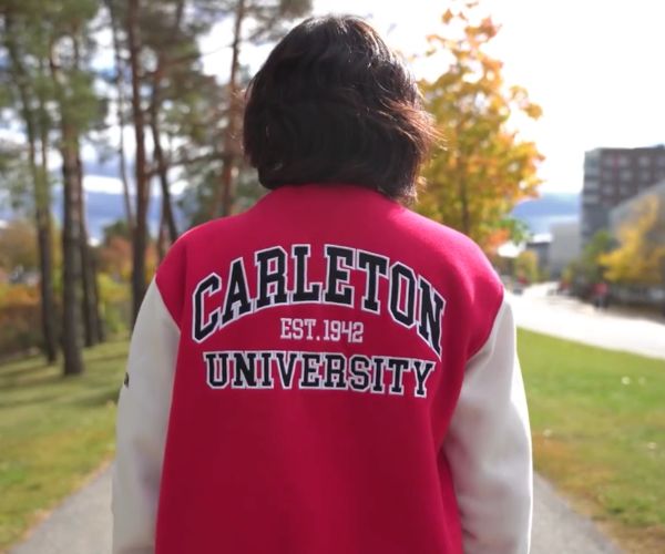 Student wearing a jacket with Carleton University est. 1942 in text on the back.