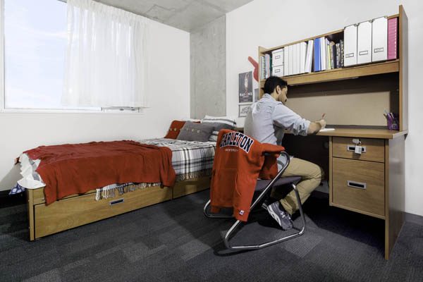 A male student in a residence room in Lennox & Addington building.