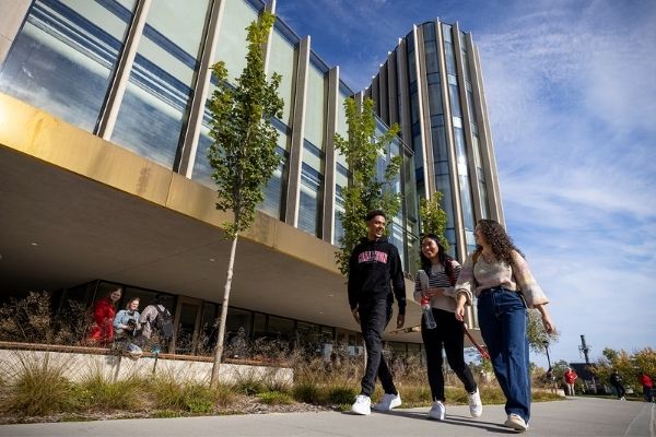 Three students walk outside of the Nicol Building.