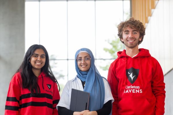 Three students standing in the lobby of the Health Sciences Building.